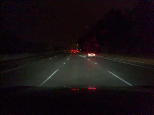 Reference driving-video frame showing a road and surrounding landscape
